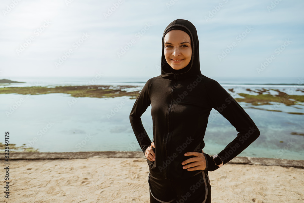 Wall mural beautiful sport muslim woman smiling. healthy woman with scarf exercising