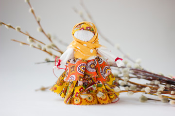 Handmade textile doll with pussy-willow on white background.