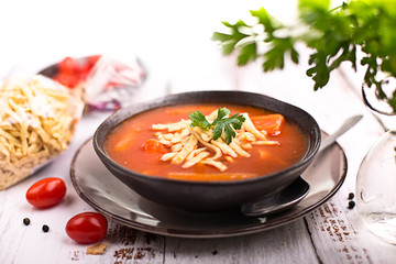 Tomato soup with noodles on a wooden table