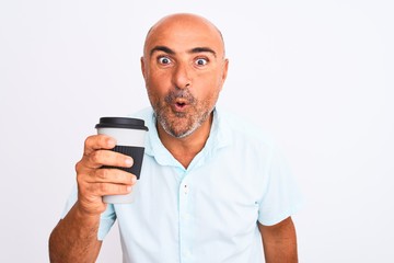 Middle age man drinking take away coffee standing over isolated white background scared in shock with a surprise face, afraid and excited with fear expression