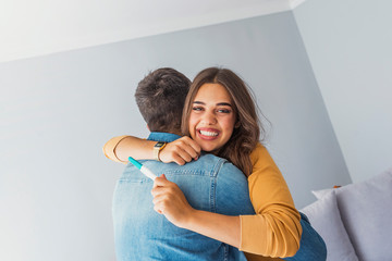 Couple taking a pregnancy test at home. A Happy excited woman making positive pregnancy test and celebrating. Excited woman getting pregnant. Woman Celebrating Positive Home Pregnancy Test Result