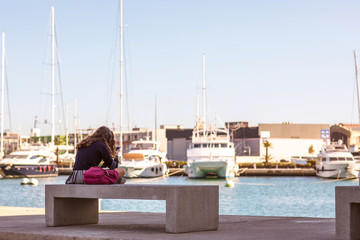 Schoolgirl communicating through her mobile phone in the port
