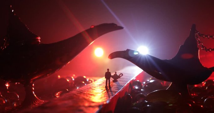 Lamp of wishes concept. Silhouette of a man standing in the middle of the road on a misty night with giant Antique Aladdin arabian nights genie style oil lamp. Creative artwork decoration