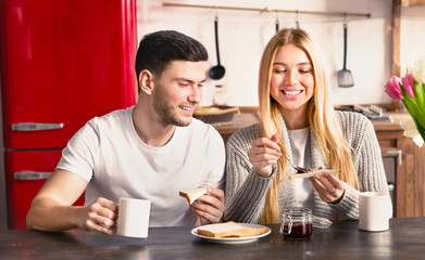 Young romantic couple is having breakfast on modern light kitchen
