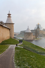 One of the main sightseeing in Pskov city - Vysokaya tower (left) and Ploskaya tower (right) of Pskov Kremlin (also Pskov Krom) and the promenade of Pskova river and Velikaya river at winter