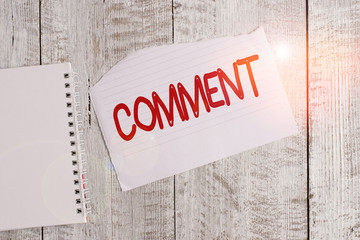 Conceptual hand writing showing Comment. Concept meaning Verbal Written remark expressing opinion Communicating reaction Torn paper and notebook sheet placed above classic wooden table