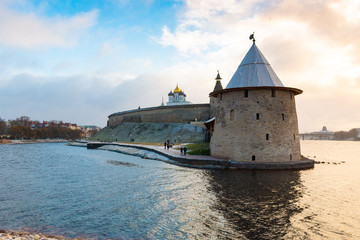 One of the main sightseeing in Pskov city - Ploskaya tower of Pskov Kremlin (also Pskov Krom) and the promenade of Pskova river and Velikaya river. Troitsky church and Kremlin walls on the background