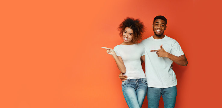 African American Couple Pointing Fingers At Copyspace, Orange Background, Panorama