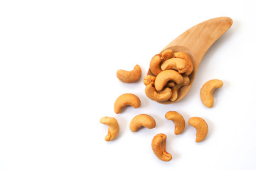Cashew nuts on a wooden spoon isolated on white background.