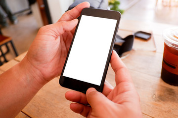 Mockup picture of business man’s hands holding smart phone with white blank screen in modern place.