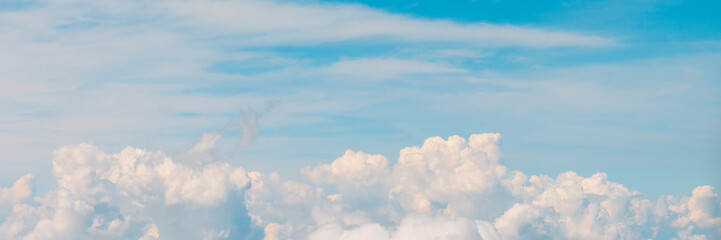 Banner 3:1. Blue sky with fluffy clouds. Aerial view from airplane window