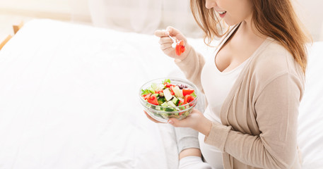 Obraz na płótnie Canvas Pregnant woman eating salad with fresh vegetables