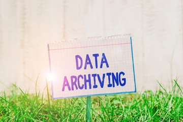 Word writing text Data Archiving. Business photo showcasing to secure and to store data for long term retention Mathematic paper attached to a stick and placed in the green grassy land