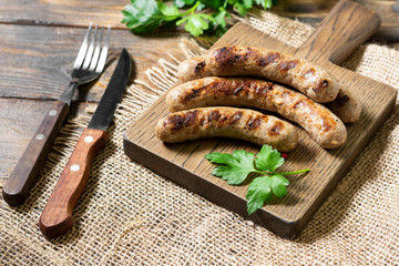 Fried sausages on a wooden Board on a brown wooden table. Rustic style