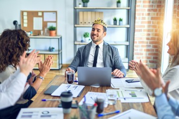 Group of business workers smiling happy and confident. Working together with smile on face applauding one of them wearing king crown at the office