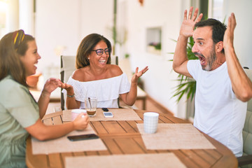 Beautiful family sitting on terrace drinking cup of coffee speaking and smiling