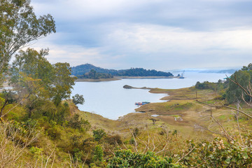 Obraz premium Beautiful lake with boats, covered with mountain and forest