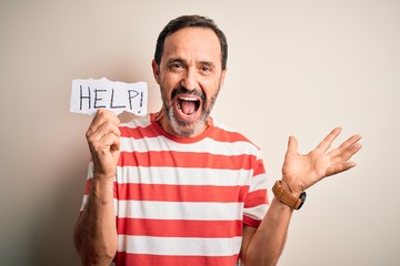 Middle age hoary man holding paper with help message over isolated white background very happy and excited, winner expression celebrating victory screaming with big smile and raised hands