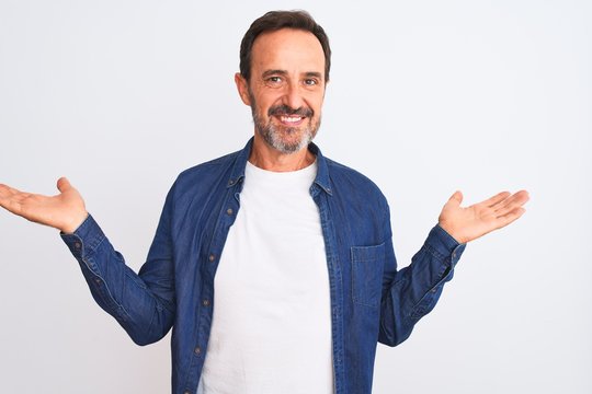 Middle age handsome man wearing blue denim shirt standing over isolated white background smiling showing both hands open palms, presenting and advertising comparison and balance