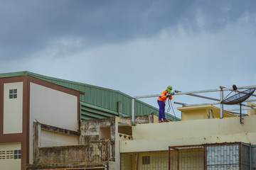 Worker welding the steel part for roof  before it is going to rain.