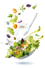 Poster Flying ingredients salad isolated on a white background. A white plate with salad and floating in the air ingredients: olives, lettuce, onion, tomato, мozzarella сheese, parsley, basil and olive oil. © SOLOTU
