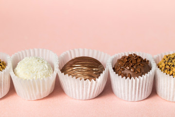 Chocolate candies close-up, chocolate on a light pink background