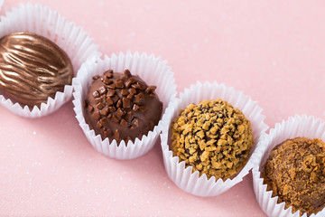 Chocolate candies close-up, chocolate on a light pink background