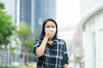 Fototapeta premium Woman wearing face mask protect filter against air pollution (PM2.5) or wear N95 mask. protect pollution, anti smog and viruses, Air pollution caused health problem. environmental pollution concept.