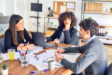 Group of business workers smiling happy and confident. Working together with smile on face  using laptop and speaking at the office