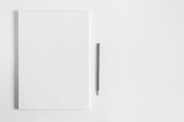 Blank sheets of paper and pencil on white background. Artist workplace. White paper stack with copy space.  Art school template for advertising.