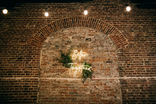 Better Together - neon sign on a brick wall in a restaurant at a wedding party. Love concept