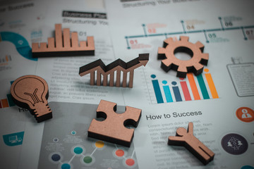 Wood figure with business icons in finance concept.