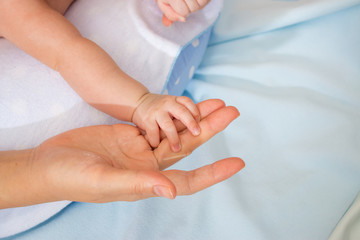 Fototapeta premium Closeup of baby hand into parents hands. Family concept