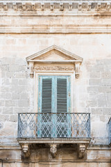 old green wooden shutters, balcony on brick wall. Ostuni, Italy