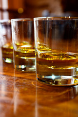 Flight of Scottish whisky, tasting glasses with variety of single malts or blended whiskey spirits on distillery tour in pub in Scotland