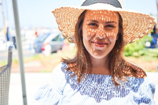 Young beautiful woman smiling happy walking on city streets on a sunny day of summer