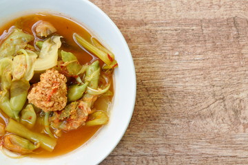 boiled mixed vegetable and fish egg in Thai spicy soup on bowl
