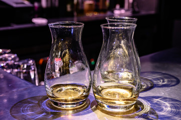 Flight of Scottish whisky, tasting glasses with variety of single malts or blended whiskey spirits on distillery tour in pub in Scotland