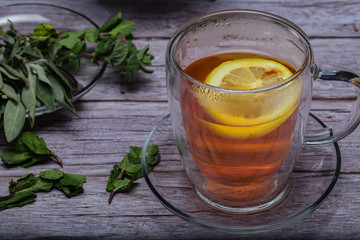 Cup of tea with teapot on a wooden table.