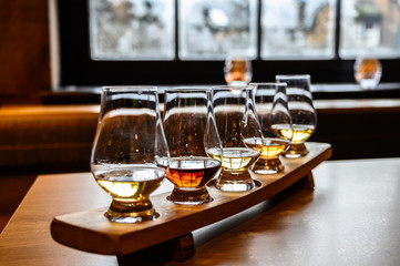 Flight of Scottish whisky, tasting glasses with variety of single malts or blended whiskey spirits...