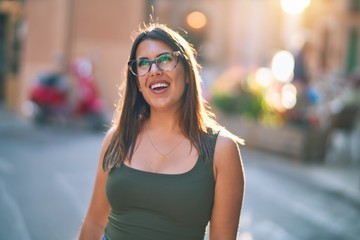 Young beautiful woman smiling happy and confident. Standing with smile on face at the town street