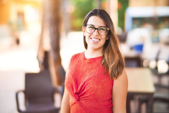 Young beautiful girl smiling happy and confident walking at the town park, standing with a smile on face