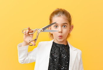 Cute little dressmaker on color background