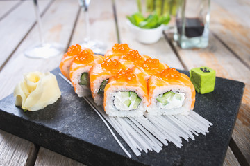 Traditional rolls with fish and rice on a white plate with sauce and wasabi. Japanese food.