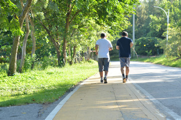 Two elderly men jogging in the park in the morning
