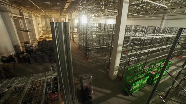 laborers assemble metal racks in spacious plant warehouse