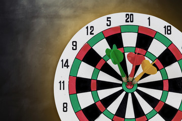 Dart arrow hitting in bullseye on dartboard