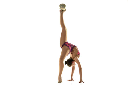 Young flexible girl isolated on white studio background. Teen-age female model as a rhythmic gymnastics artist practicing with equipment. Exercises for flexibility, balance. Grace in motion, sport.