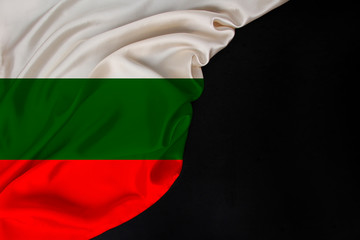 silk national flag of state of Bulgaria folded onto a black blank form, concept of tourism,...
