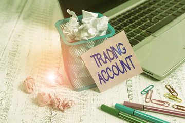 Word writing text Trading Account. Business photo showcasing investment account having securities cash or other holdings Laptop sticky note waste basket crushed paper ball clips pens vintage table